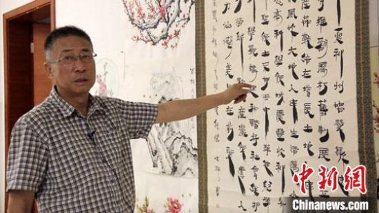 圖為朱群和他的敦煌漢簡(jiǎn)書(shū)體?！「攥?攝