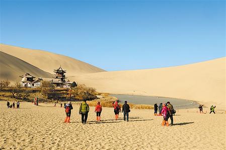 游客在敦煌市鳴沙山月牙泉景區(qū)游覽