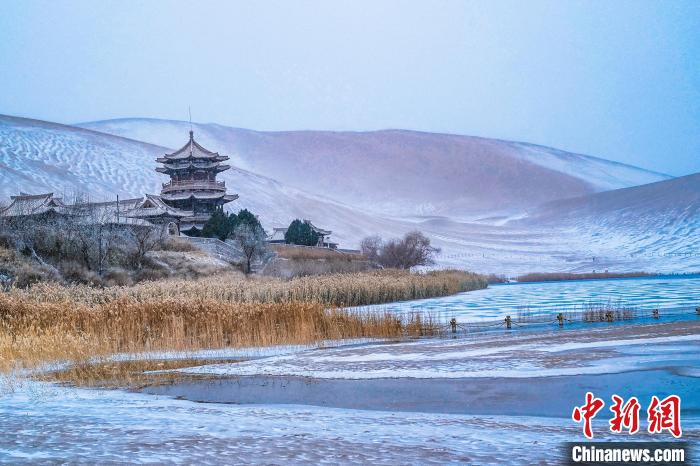 2021年11月28日，雪落鳴沙山月牙泉景區(qū)?！⊥醣筱y 攝