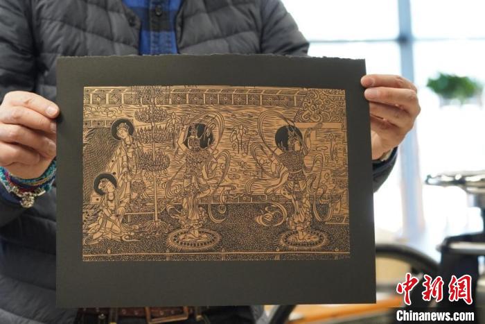 圖為手工書藝人展示敦煌雕版壁畫印刷品?！【琶赖┰?　攝