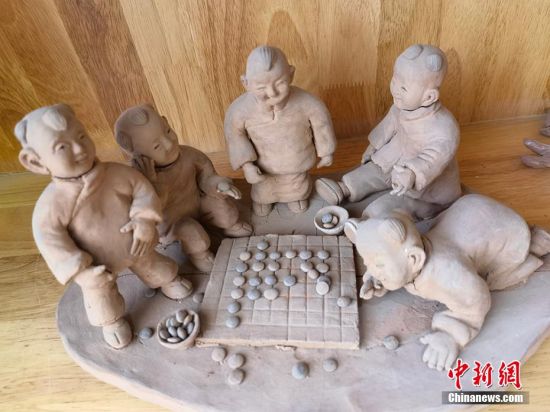 圖為泥塑作品展現(xiàn)下棋場景。 劉玉桃 攝