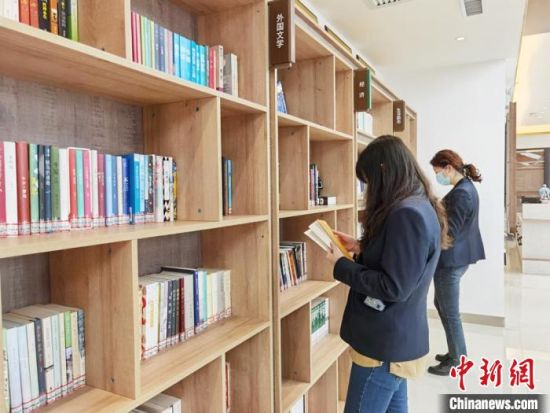 圖為在甘肅公航旅建設(shè)集團(tuán)有限公司的職工書屋，職工挑選書籍。　徐雪 攝