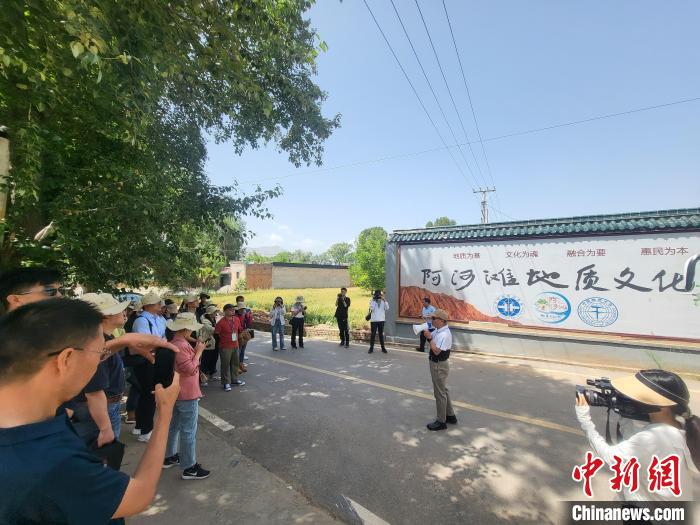 圖為中國地質(zhì)大學(北京)教授張緒教介紹村落情況。　胡友軍 攝